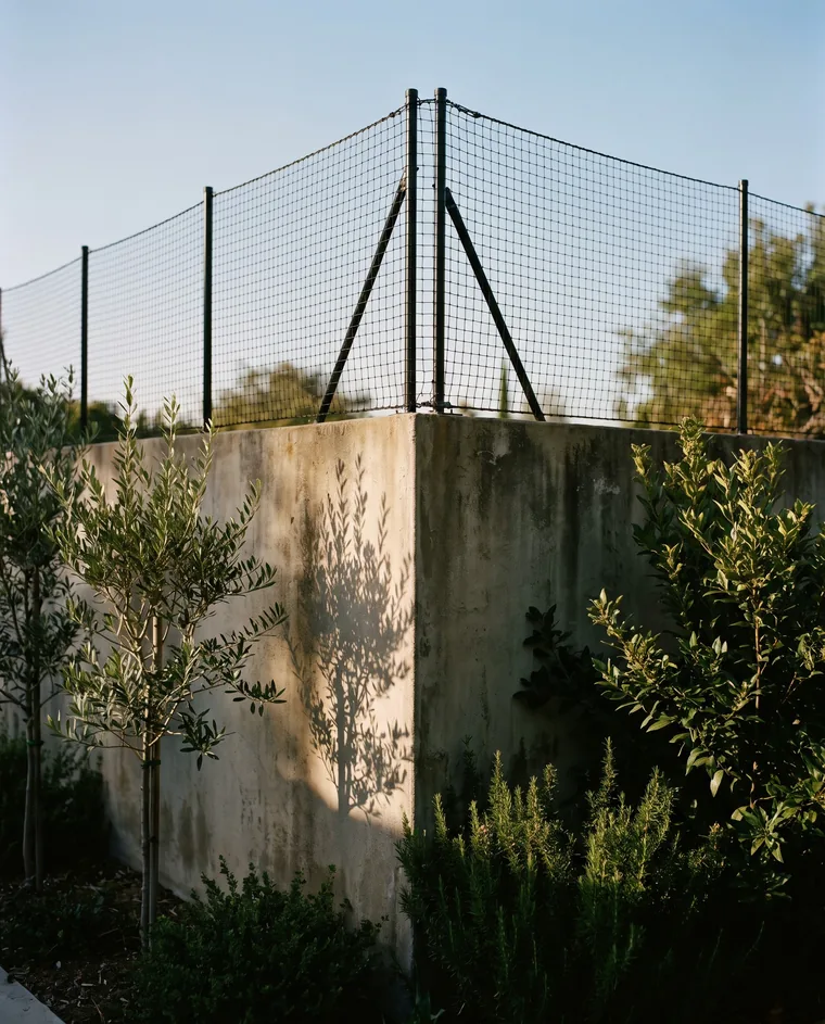Tensioned netting above a garden wall corner